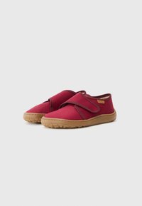 Røde stof slip-on sko med velcrorem, struktureret gummisål og afrundet tådesign. Har diskret branding på siden.