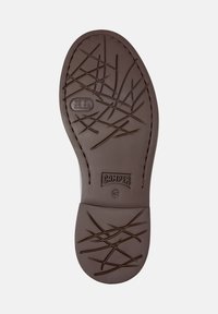 Semelle de chaussure en caoutchouc marron avec un motif texturé de lignes entrecroisées. Présente un logo et un marquage de taille, avec des bords cousus pour plus de durabilité.