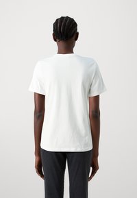 White cotton t-shirt with a crew neck and short sleeves, featuring a smooth texture and standard fit. No visible logos or patterns.