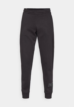 Pantalones de chándal negros hechos de una tela suave con cinturilla y puños acanalados. Presenta un logo impreso en un color contrastante en el dobladillo.
