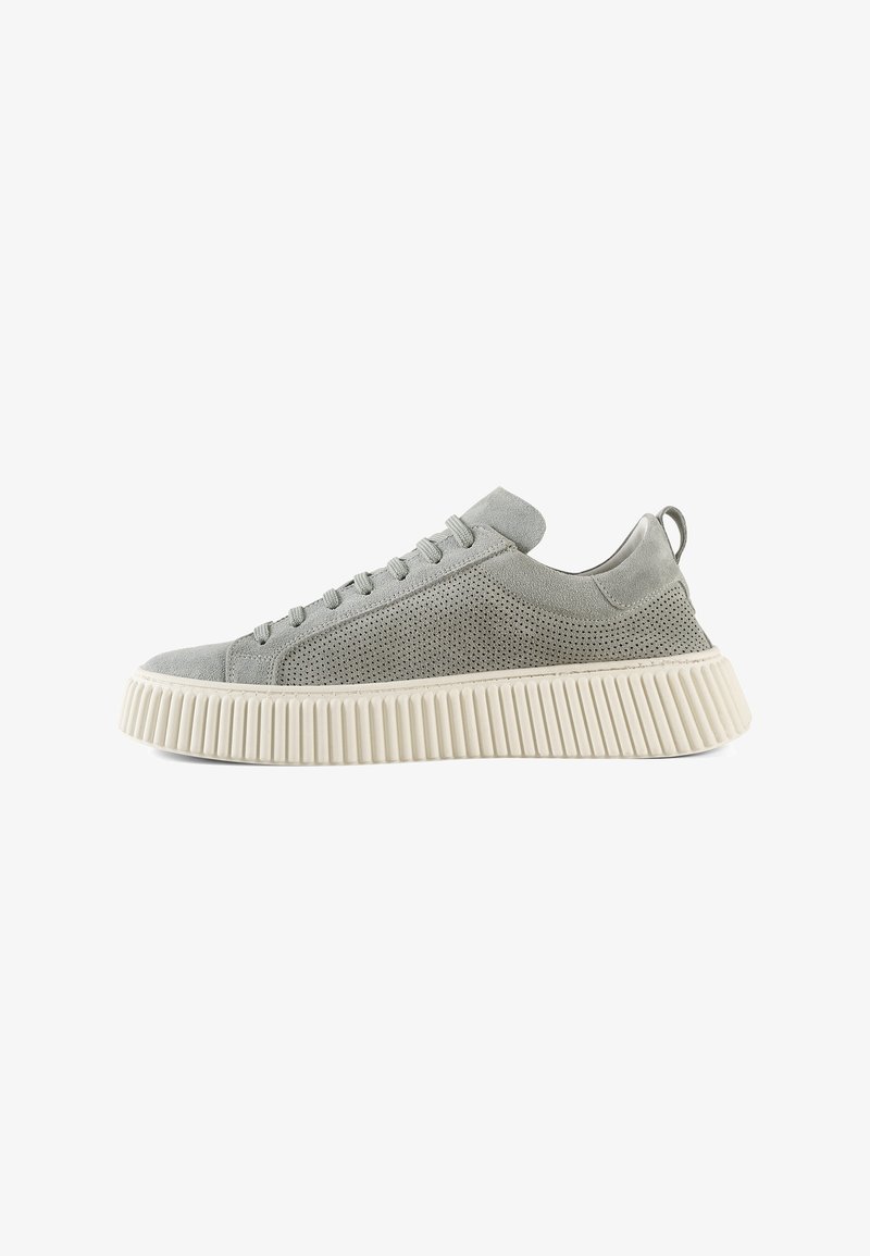 Sneaker grigio chiaro con tomaia in suede perforato, punta arrotondata e suola in gomma bianca spessa con scanalature verticali.