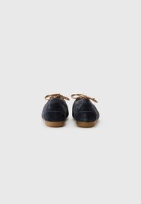 Navy suede ballerinat kengät, joissa on pyöreä kärki, ruskeat nauhat ja matala beige kumipohja. Yksinkertainen muotoilu, jossa on sileä pinta ja minimaalinen koristelu.