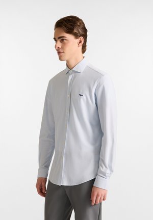 Lichtblauw gestreept overhemdd met een klassieke kraag, knoopsluiting aan de voorkant en een klein marineblauw logo; lange mouwen met knoopmanchetten.