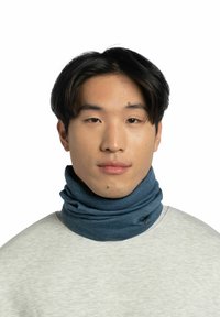 Blaues Stoff-Nackentuch mit weicher Textur, dezentem Logo, getragen über einem hellgrauen Pullover. Einfaches Design, eng anliegend für Wärme.