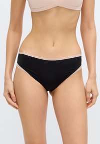 Melns bikini apakšveļas gabals ar gludu tekstūru, uz vidukļa ar kontrastējošu gai�ši bēšu joslu. Vienkāršs, mūsdienīgs dizains.