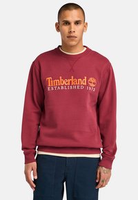 Felpa bordeaux in misto cotone, con polsini e orlo a costine, e ricamo arancione "Timberland Established 1973".