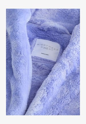 Noćna odjeća od runa svijetlo ljubičaste boje, s mekanom teksturom i oznakom na kojoj piše "NIGHTWEAR by NEXT", proizvedeno u Kini.