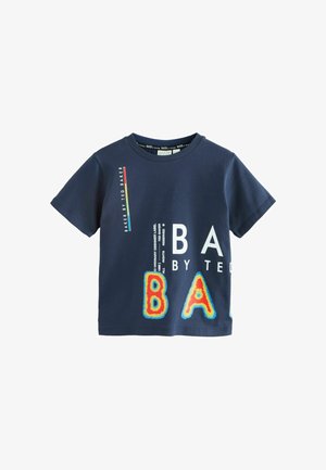 Tamsiai mėlynos spalvos medvilninė marškinėliai su ryškiais baltais ir įvairiaspalviais užrašais. Apvalus kaklo iškirpimas, trumpos rankovės ir laisvas siluetas.