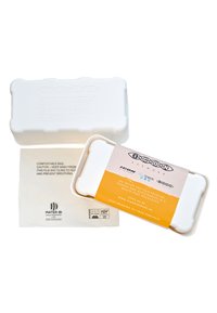 Emballage compostable blanc aux bords arrondis, avec une étiquette de marque en orange et des détails sur le produit. Accompagné d'un sac compostable.