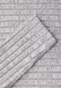 Grijze textuurstof met ribbelpatroon en afwisselend gladde strepen, met een zachte, pluche oppervlakte en een gevouwen rand.