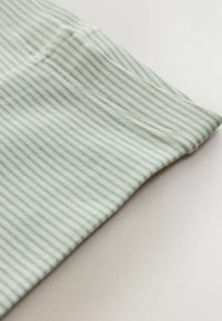 Tissu rayé bleu clair et blanc, texture douce, montrant un bord plié avec une couture soignée. Le matériau semble extensible et léger.