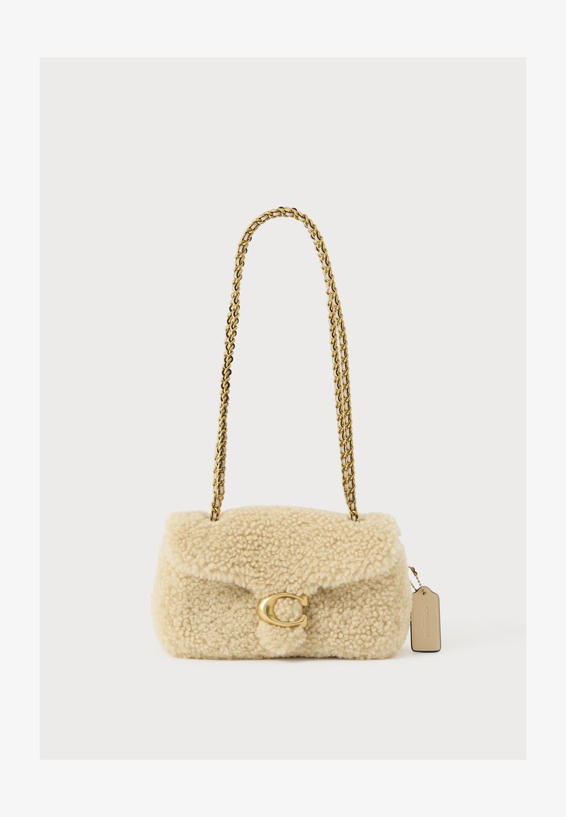 Bež ramenska torbica iz usnja z zlatim verižnim trakom in zlatim C-oblika sponko, s majhno pravokotno oznako, pritrjeno na strani.