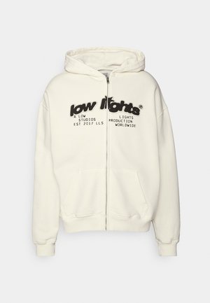 Crèmekleurige hoodie met ritssluiting, voorzakken en zwarte tekst met de woorden "low lights" en extra kleinere tekst eronder op de borst.