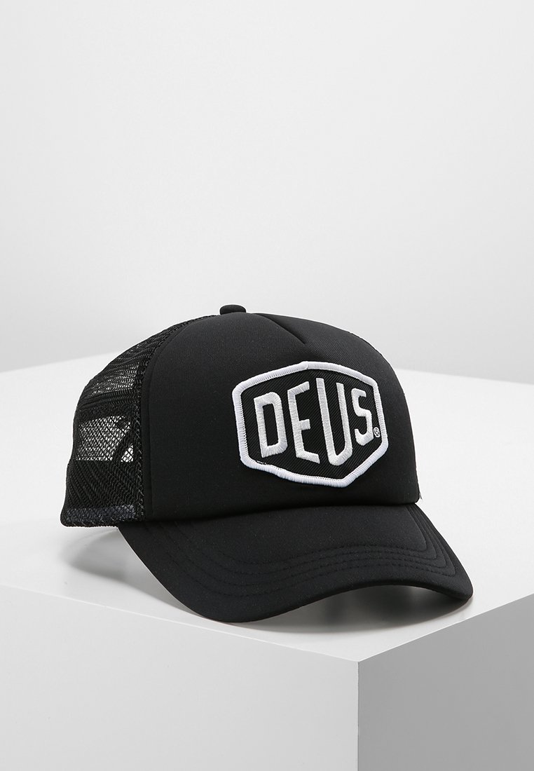 Gorra negra con visera redondeada, que cuenta con una parte frontal de tela sólida y paneles laterales de malla. En la parte frontal se muestra una insignia de logo bordado en blanco.