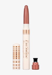Ombretto in matita cremoso di colore rosa metallico con confezione a strisce bianche e oro rosa; comprende un tappo e un mini temperamatite.