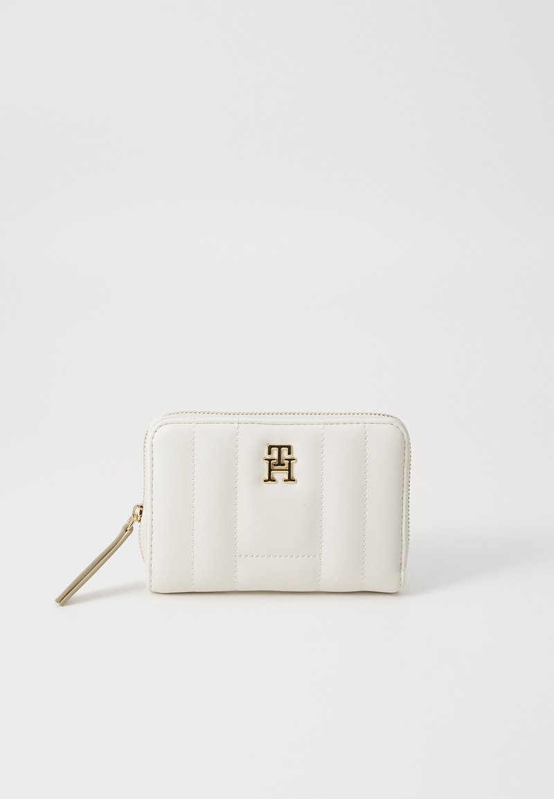 White leather wallet with vertical stitched detailing and gold logo accent. Features a zipper closure and a small, attached zipper pull.