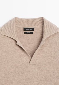Maglione in lana color beige con scollo a V e colletto a coste. Tessuto morbido con etichetta che riporta "Massimo Dutti, 100% lana, made in China."