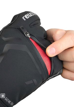 Schwarze Handschuhe mit strukturierter Oberfläche, ausgestattet mit einem Reißverschluss und rotem Netzfutter. Zeigt Branding und das Gore-Tex-Logo. Hand, die den Reißverschluss betätigt.