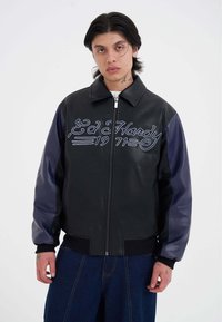 Giubbotto di pelle nera con maniche in pelle blu, con ricamo bianco "Ed Hardy 1971" sul davanti, chiusura a zip e fondo a coste.