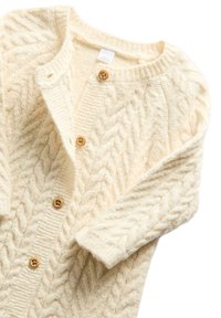Světle krémový pletený cardigan s copánkovým vzorem, kulatým výstřihem, pěti dřevěnými knoflíky a manžetami s žebrováním.