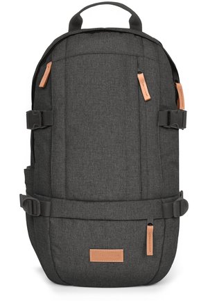 Dark gray backpack with a textured fabric. Features adjustable straps, leather accents, and a top handle. Side pockets and buckles for fastening.