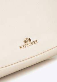 Krémová kožená kabelka s pozlaceným embosovaným logem "WITTCHEN", hladkým povrchem a zaobleným tvarem, ideální na každodenní nošení.