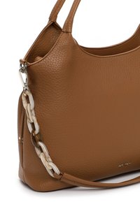 Sac à main en cuir grainé marron avec deux anses, équipé d'un ornement en chaîne décorative. Texture lisse et forme structurée.