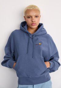 Hoodie bleu en mélange de coton, avec une poche avant, un capuchon avec cordon de serrage et un logo brodé sur la poitrine. Coupe décontractée avec des poignets côtelés.
