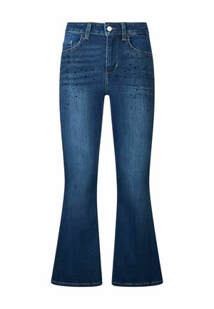 Laiendatud tumesinised teksad, mis on valmistatud denimmaterjalist, esipocketitel on dekoratiivsed mustad nupud ning talje kohal on nööbi kinnitamine.