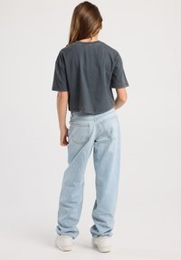 Gray cropped t-shirt paired with light blue baggy jeans. The outfit features short sleeves and a relaxed fit, with a plain design and no patterns.