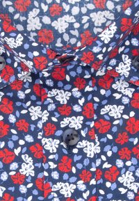 Chemise bleu marine avec motif floral rouge, blanc et bleu clair et boutons noirs sur le devant et le col.