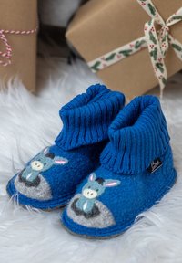 Blauwe vilten pantoffels met geribbelde gebreide boorden, voorzien van geborduurde ezelmotieven, grijze zoolaccenten en een zwart merkteken.