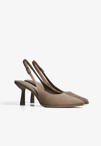 Slingback højhælede sko i taupe ruskind med spids tådesign, med en tynd rem og blokhæl for stabilitet.