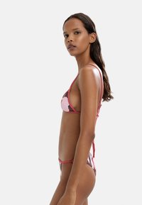 Bikini w różowo-brązowy wzór kwiatowy, cienkimi ramiączkami, trójkątnym stanikiem i zawiązywaniem z tyłu, o gładkiej teksturze materiału.