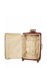 Valise bordeaux avec un intérieur beige, dispose de deux compartiments, de sangles croisées et d'une poignée rétractable. Roues pour une mobilité facile.