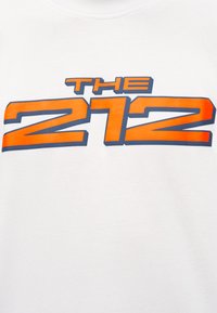 Tissu blanc avec un texte orange et bleu en gras indiquant "THE 212" centré sur la surface.