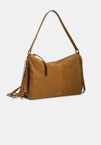 Bruine suède schoudertas met franjes, een ritssluiting aan de bovenkant en een lange schouderband. Gladde textuur en rechthoekige vorm.