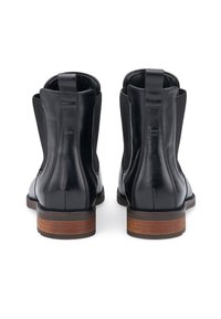 Bottes chevilles en cuir noir avec des panneaux élastiques sur les côtés, un bout arrondi et un talon en bois empilé. Texture lisse, détail minimal.