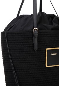 Borsa nera textured con design arrotondato, caratterizzata da una parte superiore arricciata, dettagli in pelle e una piccola etichetta con logo dorato su sfondo nero.