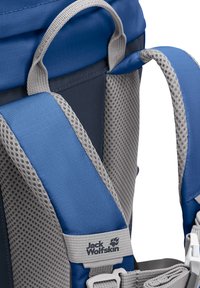 Blaue und graue Schulterriemen eines Jack Wolfskin Rucksacks mit gepolstertem Mesh und verstellbarer grauer Trageschlaufe oben.