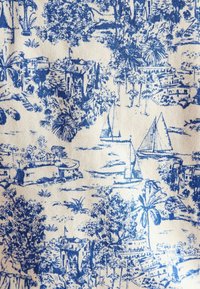 Biely textil s modrou botanickou a námořní potlačou, obsahujúci palmy, budovy a plachetnice v pôsobivom dizajne.