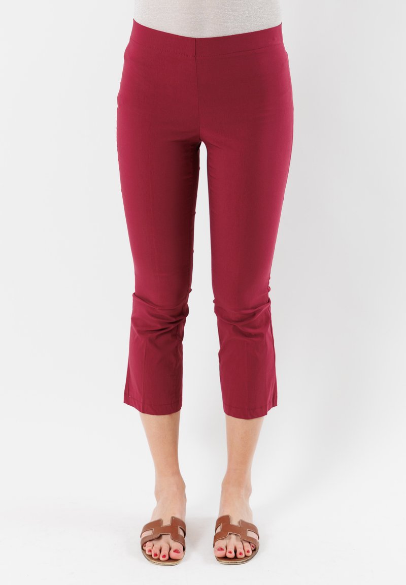 Pantaloni capri bordeaux realizzati in un tessuto liscio, con vita aderente e gambe corte, caratterizzati da un orlo pulito e senza tasche visibili.