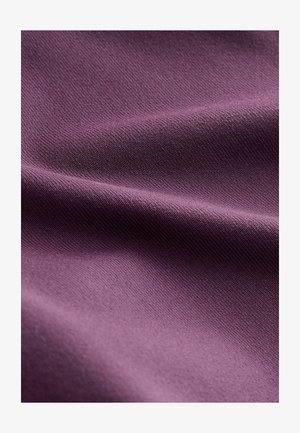 Lilla puuvillakangas, millel on sile tekstuur, näitades peeneid voltide ning ühtlast kudumismustrit. Valgus mängib pinna peal.