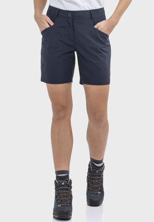 Navyblaue Outdoor-Shorts aus leichtem, schnell trocknendem Stoff mit zwei Vorderentaschen und Knopfverschluss, kombiniert mit robusten Wanderschuhen.