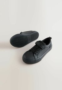 Zwarte leren sneakers met een ronde neus, vetersluiting en klittenband, een gestructureerde rubberen zool en een gladde afwerking.