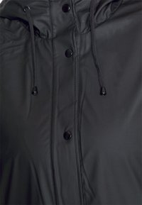 Schwarze gepolsterte Jacke mit verstellbarem Kapuzenzug, Druckknöpfen und einer glatten Textur, konzipiert für Wärme und Funktionalität.
