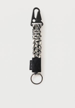 Llavero tejido de paracord en blanco y negro con un clip metálico negro en un extremo y un anillo para llaves en el otro.