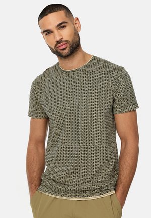 Kortærmet, fitted t-shirt i et grønt og cremefarvet geometrisk mønster med rund halsudskæring og glat bomuldsstof. Flade sømme og ingen synlige etiketter.