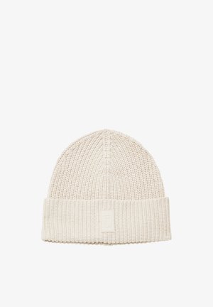 Jasno beżowa dziana czapka beanie z prążkowanym wzorem i podwiniętym mankietem, na którym znajduje się mała prostokątna naszywka z logo.