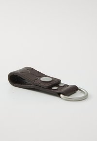 Porte-clé en cuir marron avec un design texturé, quincaillerie en argent et un anneau de clé en métal rond. Mesure environ 10 cm de long.
